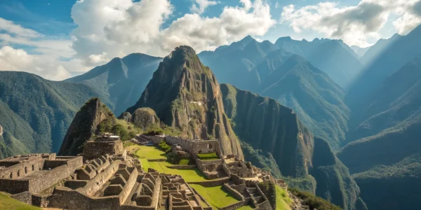 Vista panorámica horizontal de Machu Picchu, Perú, con montañas verdes y cielo azul.